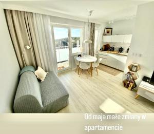 a living room with a couch and a table and a kitchen at Apartament Horizon in Gdynia