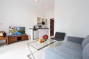 un salon avec un canapé et une table en verre dans l'établissement 1Br Poolside Apartment, Long Beach, Lanta Sport Resort 105, à Ko Lanta