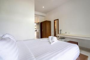 un lit blanc dans une chambre blanche avec une fenêtre dans l'établissement 1Br Poolside Apartment, Long Beach, Lanta Sport Resort 105, à Ko Lanta