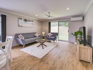 a living room with a couch and a tv at Breeze in Toogoom in Toogoom