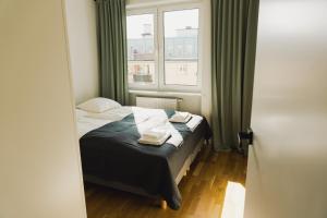a small bedroom with a bed and a window at Top Floor Apart in Gdynia