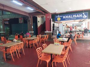 ein Restaurant mit Tischen, Stühlen und Tischen in der Unterkunft Celyn City Hotel in Kota Kinabalu