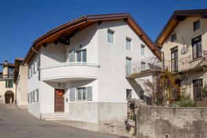 a white building with a balcony on a street at Relais Flora Arzo Appartamento superior di vacanza con posteggio in Mendrisio