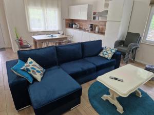 a living room with a blue couch and a table at Apartman Diana - 75 m2 - 2 Bedrooms - Grill in Jadranovo