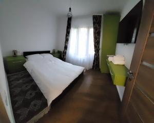 1 dormitorio con cama blanca y ventana en Racosim Residentials, en Seleuş
