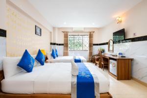 Habitación de hotel con 2 camas y escritorio en KHÁCH SẠN HỒNG PHÁT en Ho Chi Minh