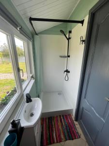 a small bathroom with a sink and a shower at Miera osta in Kocēni