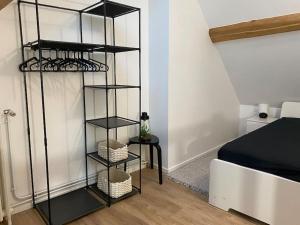 1 dormitorio con estantería de libros negros junto a la cama en Appart rénové en duplex avec terrasse et garage en Bouleurs