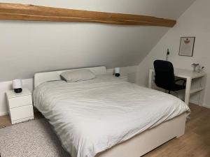 1 dormitorio con cama, escritorio y silla en Appart rénové en duplex avec terrasse et garage, en Bouleurs