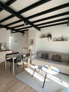 een woonkamer met een bank en een tafel en stoelen bij Appart rénové en duplex avec terrasse et garage in Bouleurs