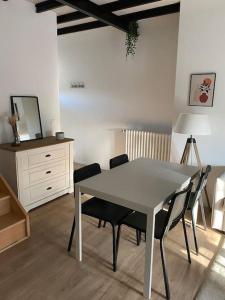 een eetkamer met een tafel en stoelen en een dressoir bij Appart rénové en duplex avec terrasse et garage in Bouleurs