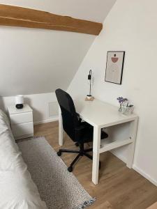 1 dormitorio con escritorio, silla y cama en Appart rénové en duplex avec terrasse et garage, en Bouleurs