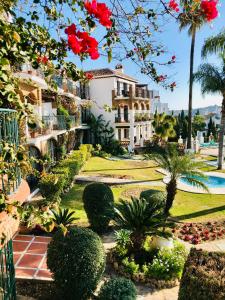 a view of a resort with palm trees and bushes at Luxury Puebla Aida with Golf & Sea View in Mijas Costa