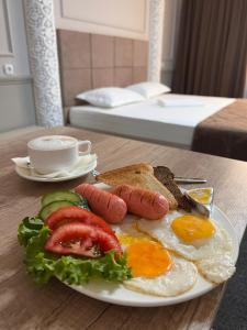 un piatto di prodotti per la colazione con salsiccia e pane tostato di Sapphire hotels a Taraz