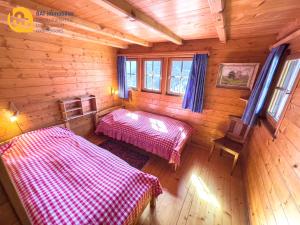 a bedroom with two beds in a wooden cabin at Chalet Vercoquin in Vercorin