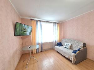 a living room with a couch and a table and a television at Kandavas 2 in Daugavpils