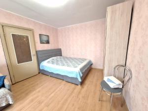 1 dormitorio con 1 cama y 1 silla en Kandavas 2 en Daugavpils