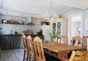 a kitchen and dining room with a wooden table and chairs at Landlig idyl på Dommergården Bed and Coffee in Læsø
