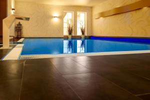 a swimming pool in a house with a tile floor at STEIGER Hotel Rathener Hof in Kurort Rathen
