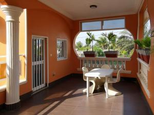 an orange room with a table and a window at Agbata Guest House in Gbata