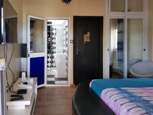 1 dormitorio con 1 cama y baño en Agbata Guest House 