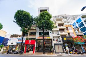 uma rua da cidade com edifícios altos e uma árvore em KHÁCH SẠN HỒNG PHÁT em Ho Chi Minh