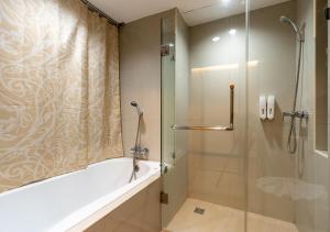 Greenview Ekkamai10 Suite في بانكوك: حمام مع دش وحوض استحمام