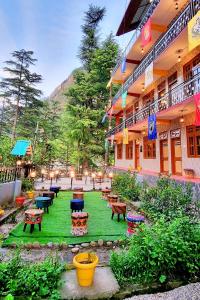 a courtyard with tables and benches in a building at Hogwartz Hostel in Kasol