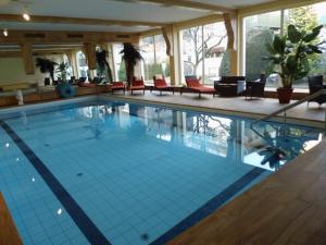 a large swimming pool with blue tiles in a building at Ferienwohnung am Kurpark in Bad Lauterberg
