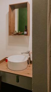 lavabo blanco en una encimera de madera con espejo en #StarsBoxtragliulivi en Molfetta
