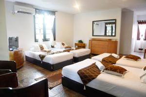 a room with four beds and a mirror at 101 Resort & Spa, Janda Baik in Kampong Sum Sum