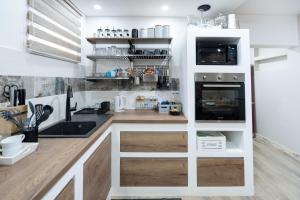 une cuisine avec un comptoir avec un évier et un micro-ondes dans l'établissement Cozy House In Nature With Hot Tub - Happy Rentals, à Kelemen