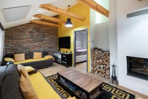 un salon avec un canapé et une cheminée dans l'établissement Cozy House In Nature With Hot Tub - Happy Rentals, à Kelemen