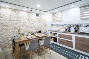 une cuisine et une salle à manger avec une table et des chaises en bois dans l'établissement Cozy House In Nature With Hot Tub - Happy Rentals, à Kelemen