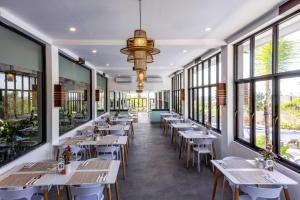 una fila de mesas y sillas en un restaurante con ventanas en Luxotic Private Villa and Resort, en Nusa Dua