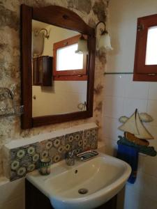 een badkamer met een wastafel en een spiegel bij Casa con vista lago, Civitella Alfedena in Civitella Alfedena