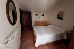 a bedroom with a white bed and a mirror at Casa con vista lago, Civitella Alfedena in Civitella Alfedena