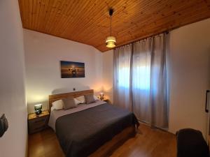 Un dormitorio con una cama y un techo de madera. en Apartments Angela Rab, en Supetarska Draga
