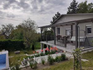a house with a deck and flowers in the yard at Holiday home in Balatongyörök 42286 in Balatongyörök