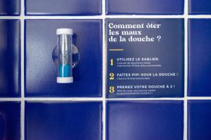 un panneau sur un mur bleu de la salle de bains carrel&eacute;e avec un conteneur dans l'&eacute;tablissement Le Lieu Dit, &agrave; Nantes