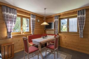 a dining room with a table and chairs and windows at Ferienwohnung Michael Novablick in Gaschurn