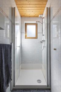 La salle de bains est pourvue d'une douche avec une porte en verre. dans l'établissement Ferienwohnung Michael Novablick, à Gaschurn