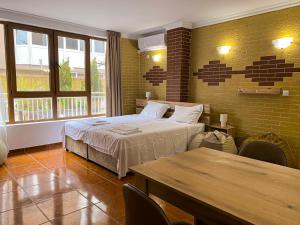 a bedroom with a bed and a table and windows at Casa Beach in Ravda