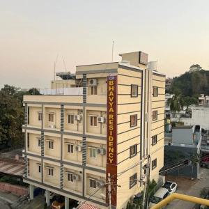 um grande edifício branco com um cartaz em SRI BHAVYARESIDENCY em Bhadrachalam