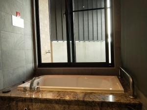 a bath tub in a bathroom with a window at MI YUE Boutque Motel in Taiping