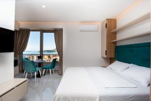 a bedroom with a bed and a table with chairs at Aura Tower Aparments by In Property in Rafailovici +257 photos