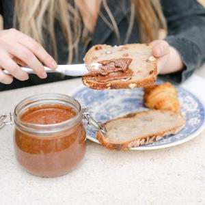 una persona che tiene in mano un pezzo di pane e un barattolo di salsa di Le Lieu Dit a Nantes