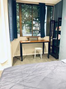a bedroom with a desk and a chair next to a window at 东京中心全新装修宽敞明亮的公寓 3分钟步行路程到门前仲町站 两条地铁线直达东京上野新宿201 in Tokyo