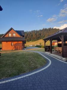 a house with a gazebo next to a yard at Pod Świerkami in Kacwin