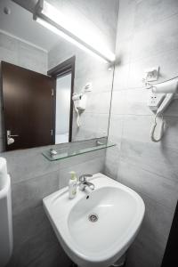 La salle de bains est pourvue d'un lavabo blanc et d'un miroir. dans l'établissement Casa Amur, à Jupiter